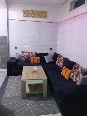 a living room with a blue couch and a table at الحي المحمدي أكادير in Oulad Akkou