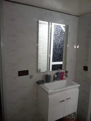 a bathroom with a white sink and a mirror at الحي المحمدي أكادير in Oulad Akkou