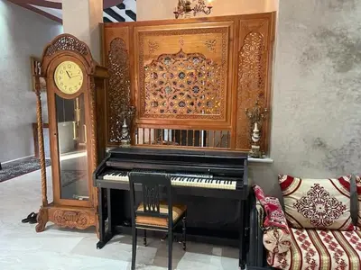 a piano in a room with a clock and a chair at Exclusive Villa Privée 5 Chambres Route de L Ourika in Sidi Bouzguia