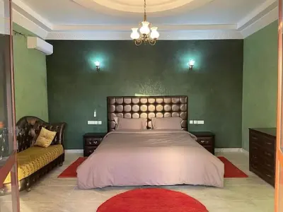 a bedroom with a large bed and a couch at Exclusive Villa Privée 5 Chambres Route de L Ourika in Sidi Bouzguia