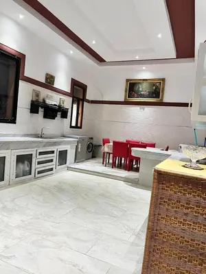 a living room with a table and red chairs at Exclusive Villa Privée 5 Chambres Route de L Ourika in Sidi Bouzguia