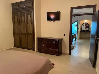 a bedroom with a bed and a dresser and a television at Exclusive Villa Privée 5 Chambres Route de L Ourika in Sidi Bouzguia