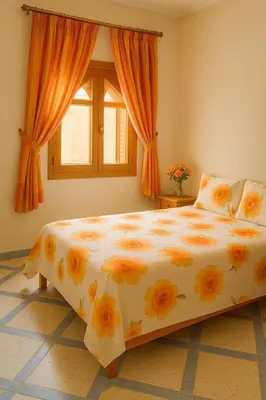 a bedroom with a large bed with flowers on it at Tazouta Farm Villa with Pool in Tazouta