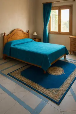 a bedroom with a bed with a blue blanket on it at Tazouta Farm Villa with Pool in Tazouta