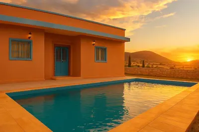 a house with a swimming pool in front of a sunset at Tazouta Farm Villa with Pool in Tazouta