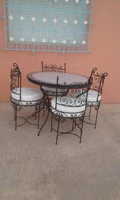 a table and two chairs and a table and a wall at Tazouta Farm Villa with Pool in Tazouta