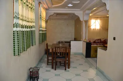 a dining room with a table and a kitchen at Appart Porte de la Médina in Fès