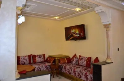 a living room with a couch and a painting on the wall at Appart Porte de la Médina in Fès
