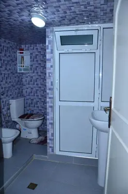 a bathroom with two toilets and a stall with a door at Appart Porte de la Médina in Fès
