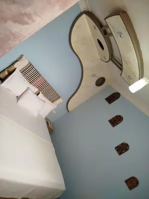 a room with a bed and a guitar on the wall at Appart Porte de la Médina in Fès