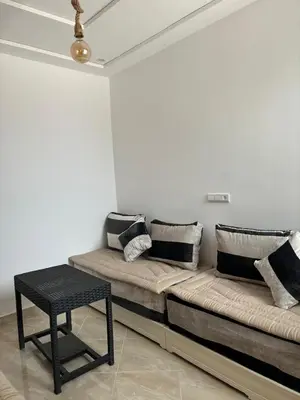 a couch sitting in a room with a table at Saidia Beach appartement in Oulad Akkou