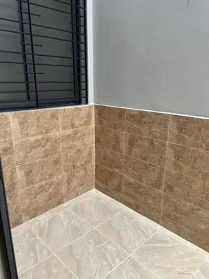 a bathroom with a shower with brown tile at Saidia Beach appartement in Oulad Akkou
