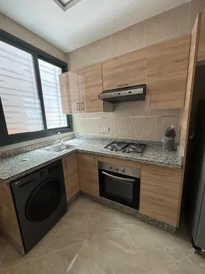 a small kitchen with a stove and a sink at Saidia Beach appartement in Oulad Akkou