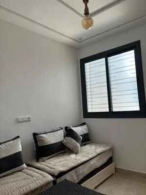 a living room with a couch and a window at Saidia Beach appartement in Oulad Akkou