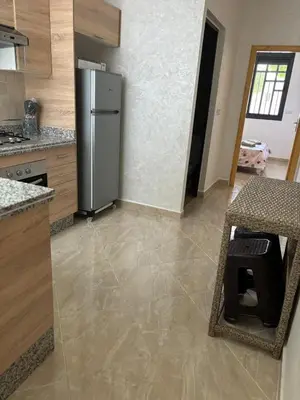 a kitchen with a stainless steel refrigerator in a room at Saidia Beach appartement in Oulad Akkou