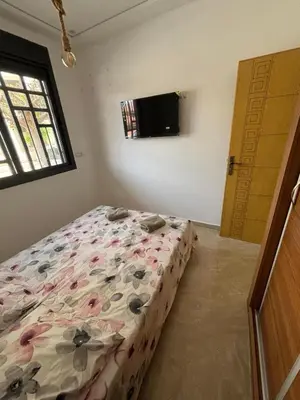 a bedroom with a bed with flowers on it at Saidia Beach appartement in Oulad Akkou