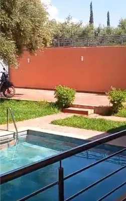 a hot tub in a yard next to a fence at Villa Mina in Aghmat