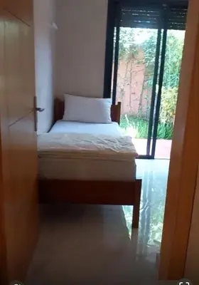 a small bed in a room with a window at Villa Mina in Aghmat