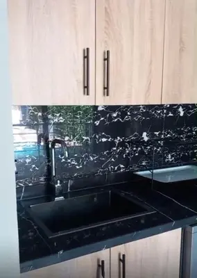 a kitchen with a sink and a black counter top at Villa Mina in Aghmat