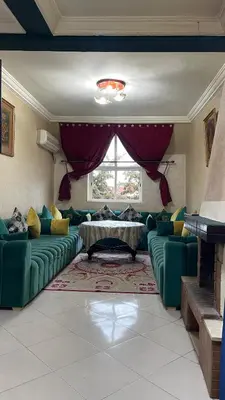 a living room with a green couch and a table at Blange neige in Ifrane