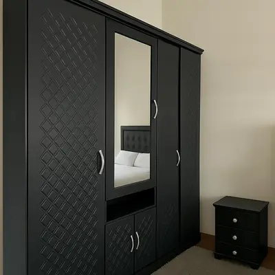 a black cabinet with a mirror and a bed at Residence Kawtar Meknès Marjane 2 in Meknès