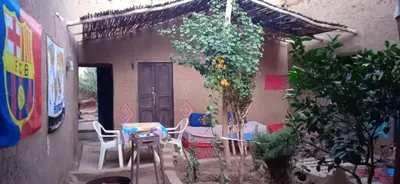a patio with a table and chairs and a plant at Dar itran 2 in Mhamid
