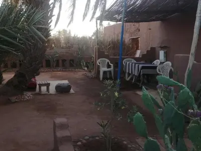a patio with a table and chairs in a yard at Dar itran 2 in Mhamid
