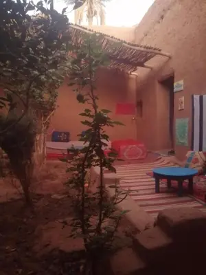 a room with a table and a bed in a building at Dar itran 2 in Mhamid