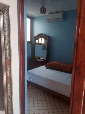a blue bedroom with a bed and a mirror at Appartment Dar Immi Medina Your Cozy Oasis in the Heart of Marrakech in Oulad Akkou