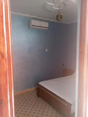 a small bedroom with a bed and a blue wall at Appartment Dar Immi Medina Your Cozy Oasis in the Heart of Marrakech in Oulad Akkou