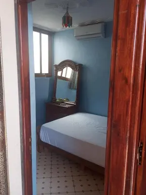 a blue bedroom with a bed and a mirror at Appartment Dar Immi Medina Your Cozy Oasis in the Heart of Marrakech in Oulad Akkou