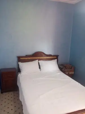 a bedroom with a white bed with a wooden headboard at Appartment Dar Immi Medina Your Cozy Oasis in the Heart of Marrakech in Oulad Akkou