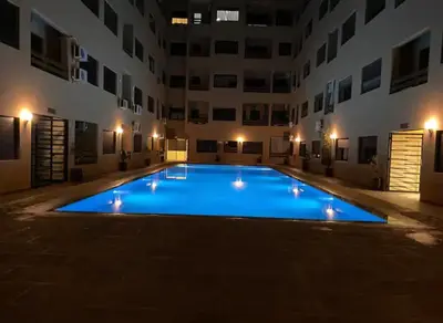 a large swimming pool in a building at night at La Joie de Vivre in Oulad Akkou