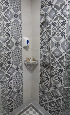 a shower in a bathroom with a tile wall at Atlas Front in Marrakech
