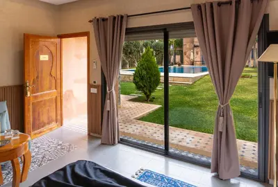 a room with a sliding glass door with a view of a yard at Atlas Front in Marrakech