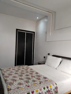 a bedroom with a bed with a floral blanket on it at شقة مفروشة in Oulad Akkou