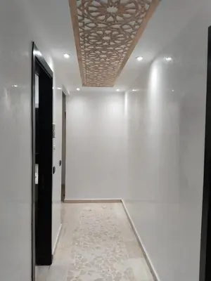 a hallway with a white wall and a ceiling at شقة مفروشة in Oulad Akkou