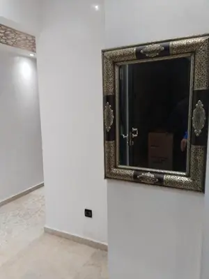 a mirror on a wall in a room at شقة مفروشة in Oulad Akkou