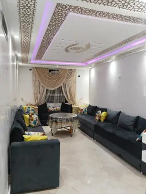 a living room with a couch and a table at شقة مفروشة in Oulad Akkou