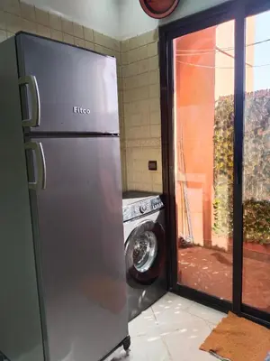 a refrigerator in a kitchen next to a washing machine at شقة مفروشة in Oulad Akkou