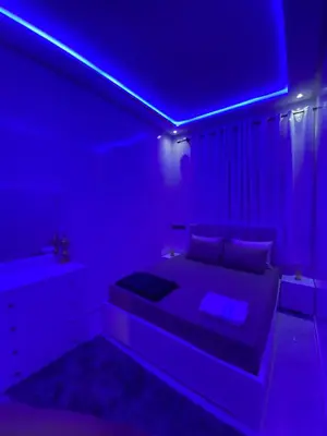 a bedroom with a bed with a blue lighting at Unique et strategique in Meknès