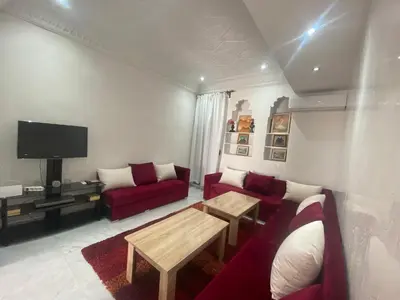 a living room with a red couch and a tv at Unique et strategique in Meknès