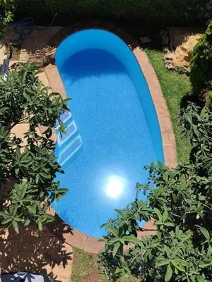 a swimming pool in a yard with plants at Maison avec piscine in Oulad Akkou