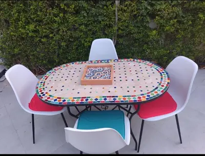 a table with chairs around it with a box on it at Maison avec piscine in Oulad Akkou