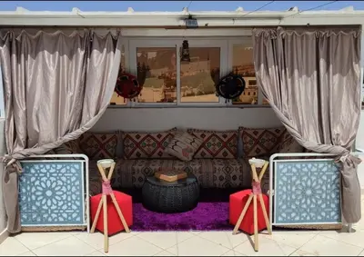 a living room with a couch and curtains and a table at Maison avec piscine in Oulad Akkou