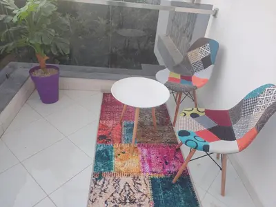 a room with two chairs and a table and a rug at Maison avec piscine in Oulad Akkou