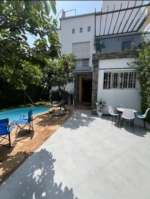 a patio with chairs and a table and a pool at Maison avec piscine in Oulad Akkou