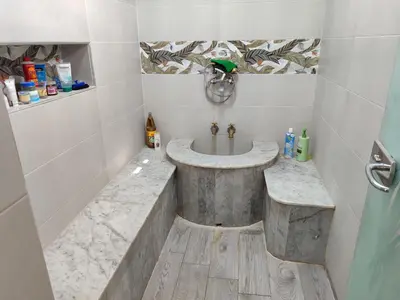 a bathroom with a marble sink and a shower at Maison avec piscine in Oulad Akkou