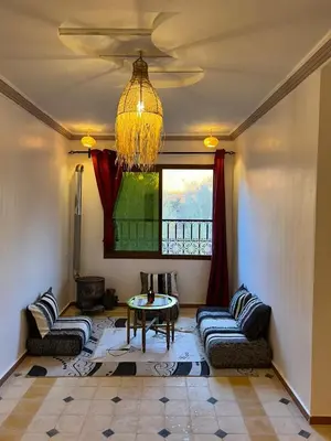 a living room with couches and a table and a window at Kasbah Ait Marghad in Aït Ougliff