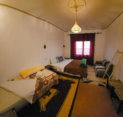a room with two beds and a couch and a window at Kasbah Ait Marghad in Aït Ougliff